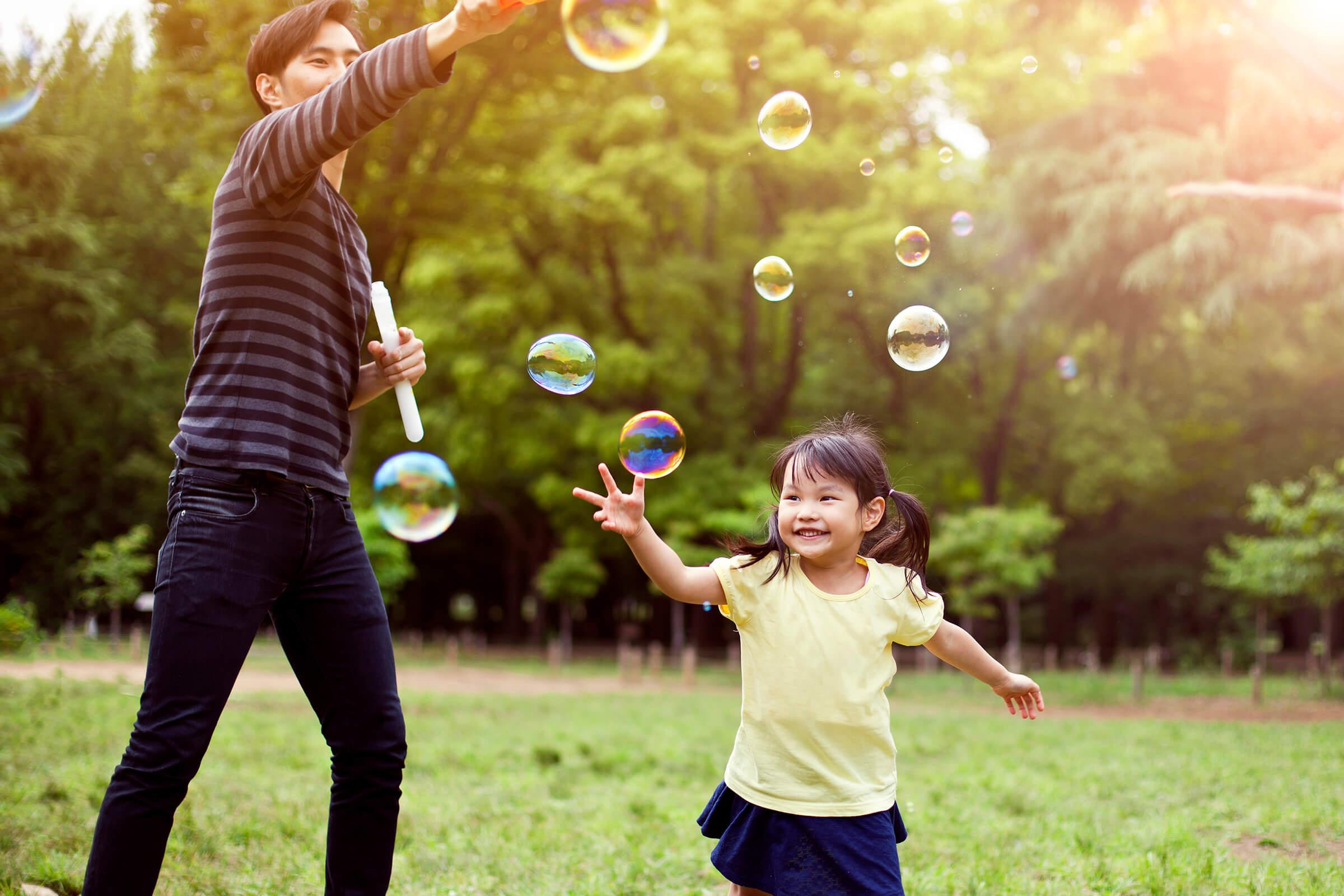 Father and daughter having fun in park with Soap Bubbles iStock-501485932.jpg